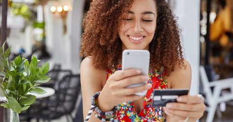 African American woman with credit card and phone