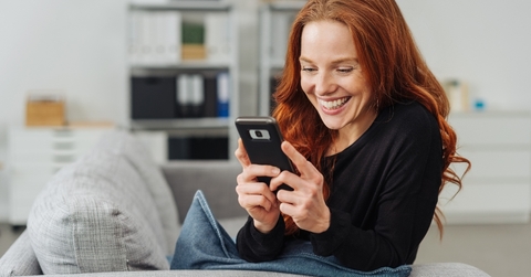Smiling young woman using cellphone