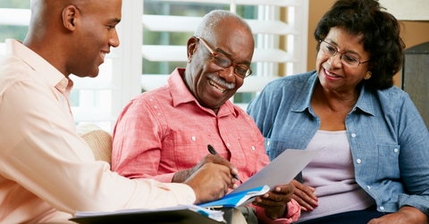 elderly man signing a document