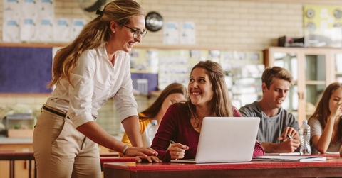 high school professor helping student in class