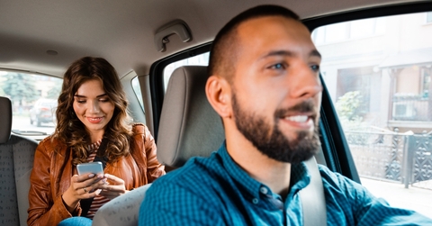Smiling man driving woman