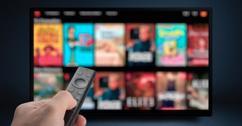 man streaming tv programs using remote