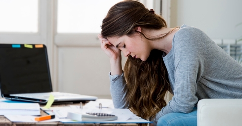 Woman leaning over table looking at bills
