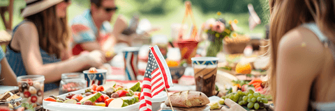 A group of friends sit at a picnic table to celebrate the Fourth of July.