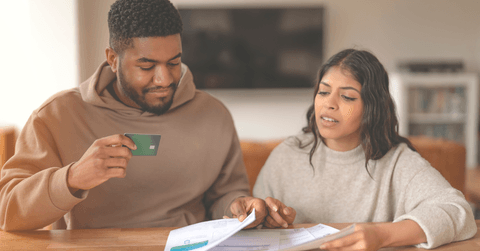 A couple discusses credit card bills together.