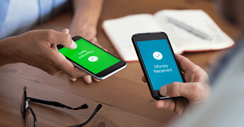 Two people hold phones and send money with a mobile payment app. 