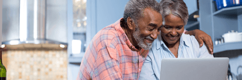 smiling seniors on laptop
