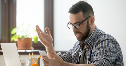 Confused man checking phone
