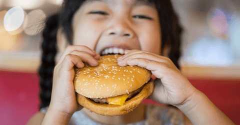 Happy girl eating a burger