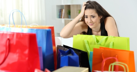 worried shopaholic woman after multiple purchases 