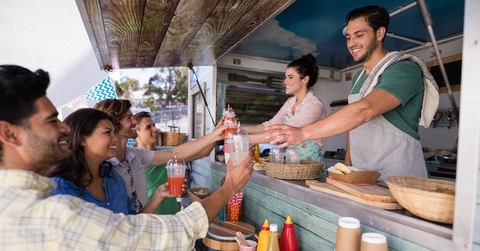 waitress and waiter giving juice to customer at counter