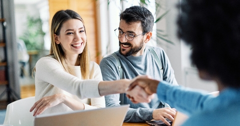 young couple shaking hands deal contract real estate investment