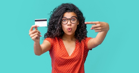 young african american woman in trendy spectacles smiling and holding credit card 