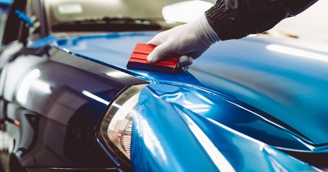 car wrapping specialist putting vinyl foil or film on car