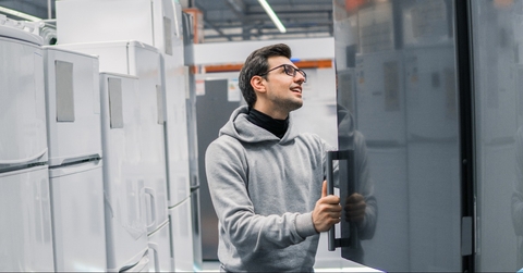 male customer choosing large fridges in domestic appliances section