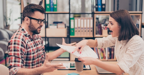 Young frustrated woman yelling and screaming on her colleague