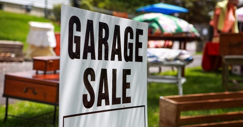 Garage sale sign on the lawn of a suburban home