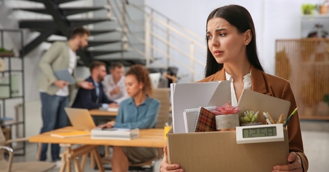 dismissed young woman carrying box with stuff in office