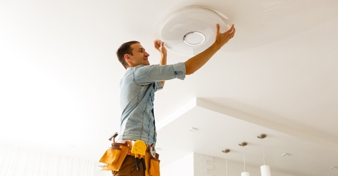 electrician is installing and connecting a lamp to a ceiling