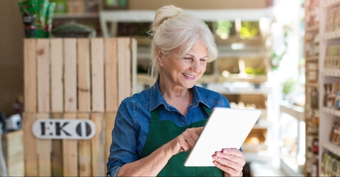 shop assistant with digital tablet in small grocery store