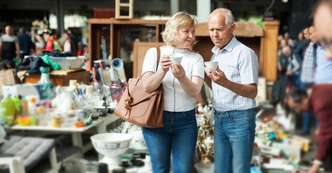 mature family couple choosing vintage dishes on street market
