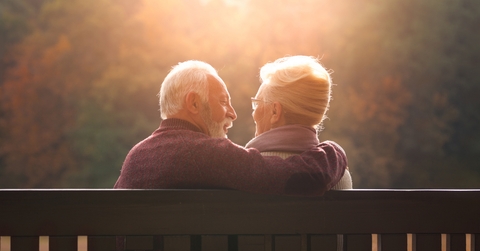senior couple sitting on bench in autumn park