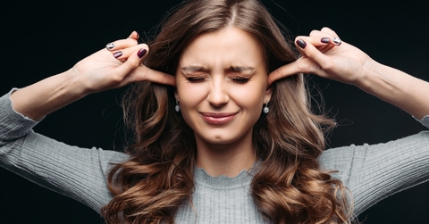 young beautiful woman closing eyes and blocking ears with fingers