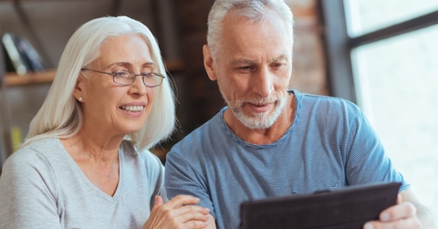 happy senior couple using tablet at home