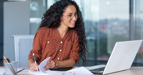 businesswoman working inside office with documents and laptop