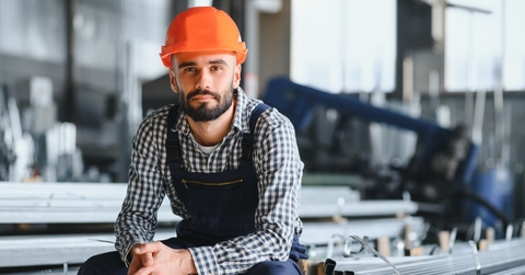 worker wearing uniform and hard hat in a steel factory
