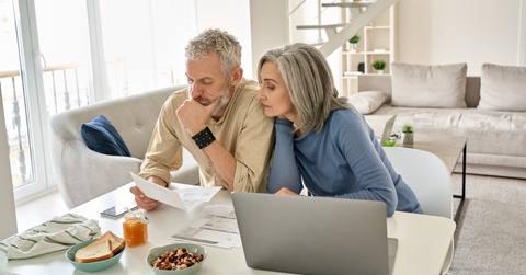senior couple sitting on table reviewing documents