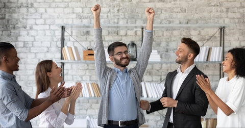 employees congratulating successful colleague with promotion