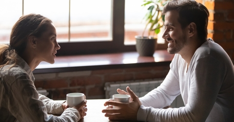 couple sitting in cafe talking drinking tea or coffee