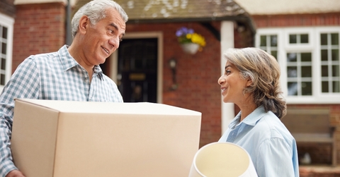 mature couple carrying boxes on moving day