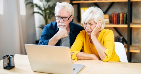 elderly couple is looking puzzled on the laptop screen