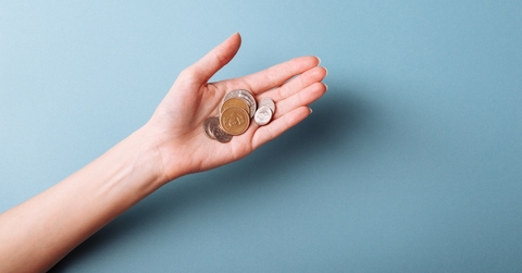 womans hand holding a heap of coins
