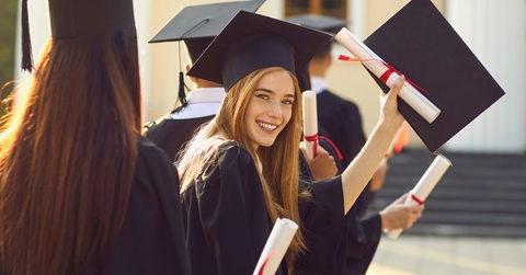 smiling college graduate standing with diploma