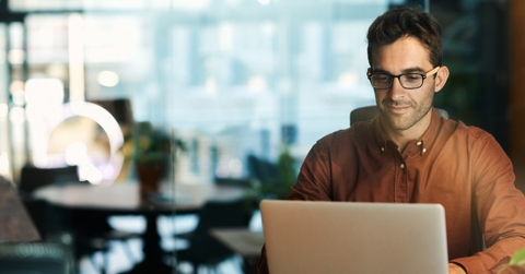 businessman wearing glasses using laptop at work