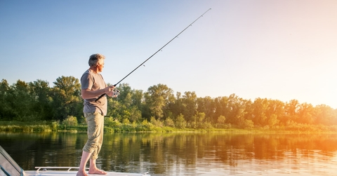 senior man standing on boat fishing