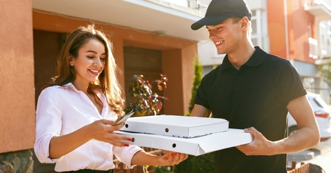 man delivering a pizza to a woman