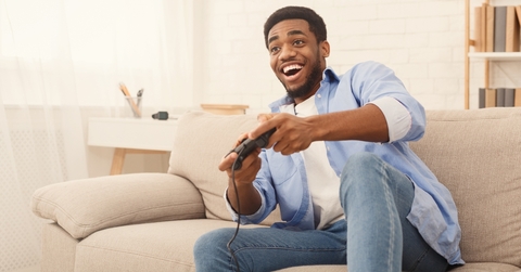 young man playing video games at home