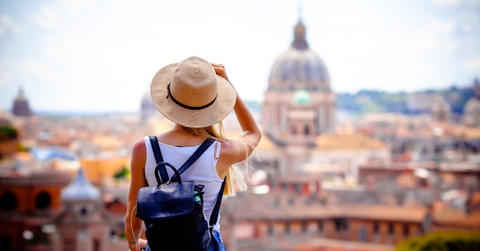 female tourist wearing black backpack and sunny hat exploring rome while on vacation