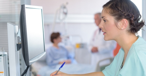 female medical assistant using pen to write on form 
