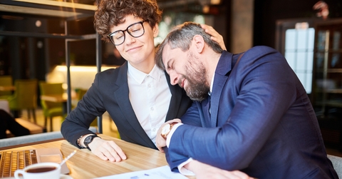 man in business suit leaning to a female colleague
