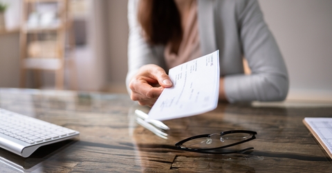 businessperson's hand holding cheque