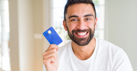 man holding credit card with a happy face