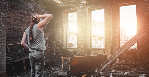 man house owner stands inside his burnt house