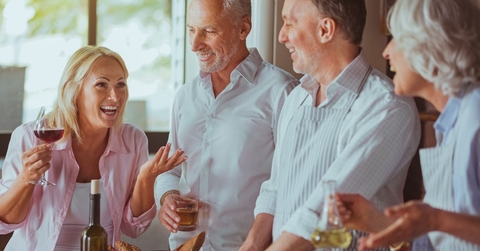 happy and relaxed couple are talking and enjoying drinks before starting dinner.