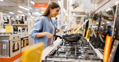 Young woman choosing gas stove