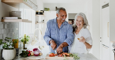 senior couple is preparing a meal together.